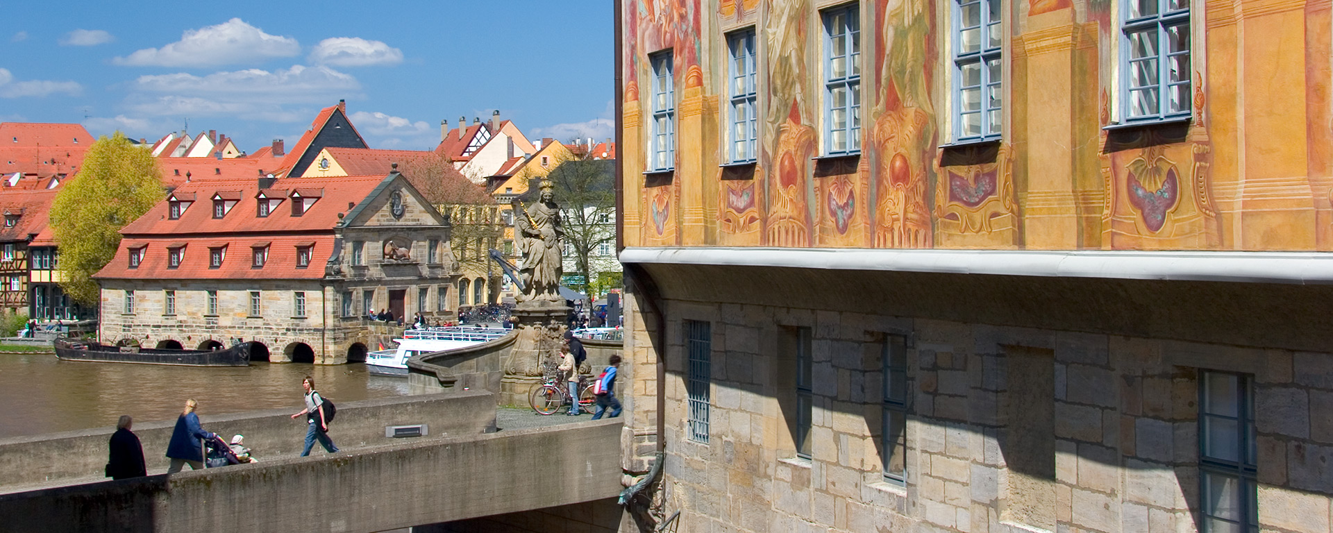 Blick von der oberen Rathausbrücke in Bamberg auf die Schiffsanlegestelle am Kranen mit der Fassade des Alten Rathauses Bamberg im Vordergrund